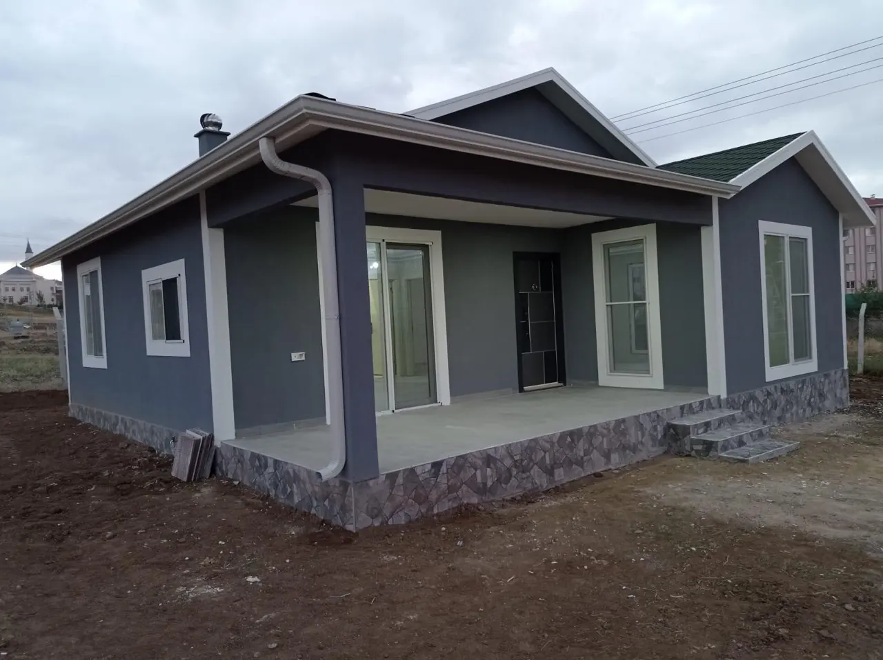100 m² Çelik Ev: gri cephede köşe pencereleri