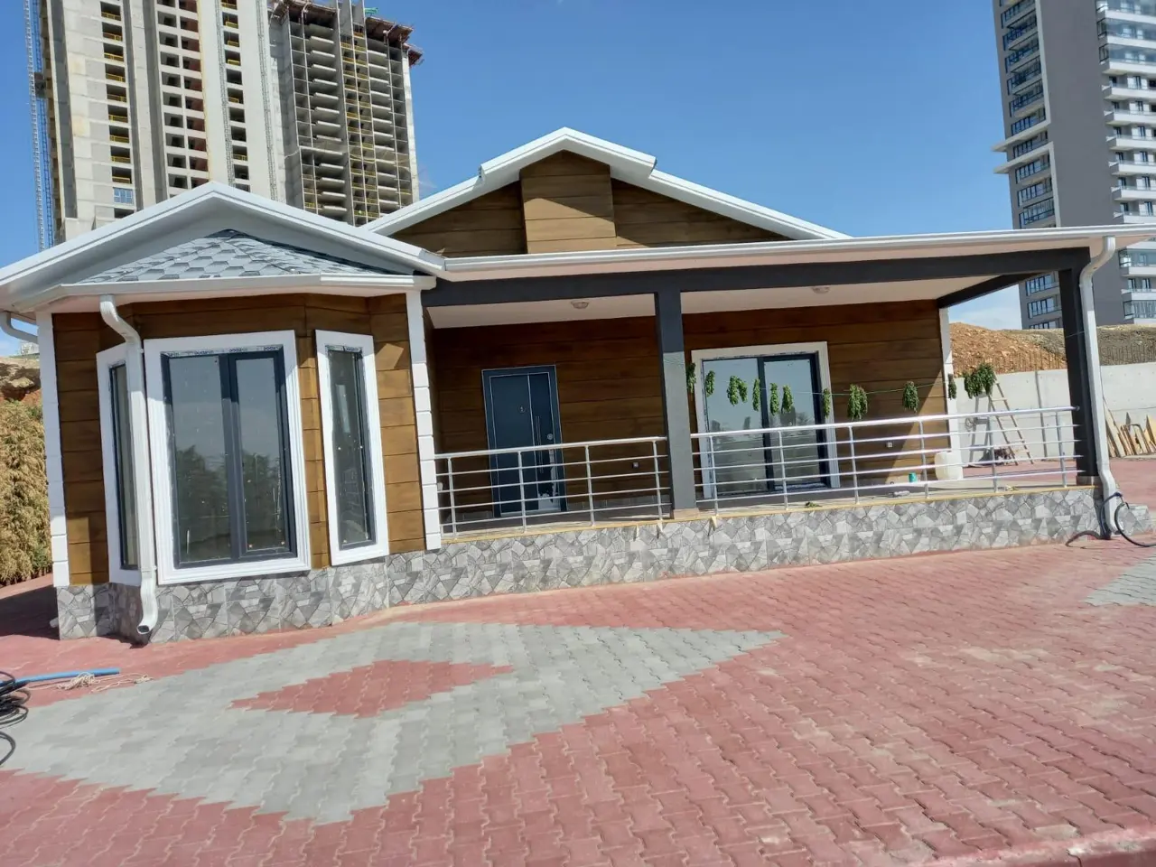 100 m² Çelik Ev: kahverengi cephe ve geniş veranda