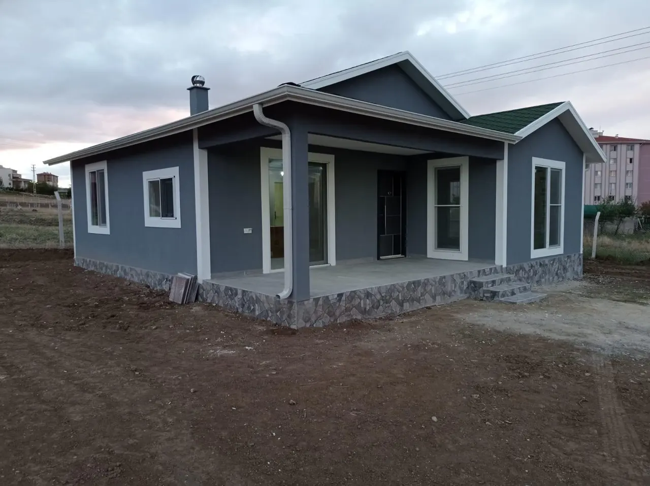 100 m² Çelik Ev: gri cephe ve bahçe yönü