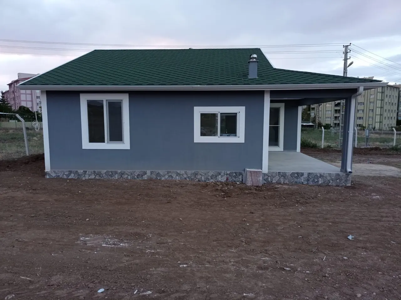 100 m² Çelik Ev: uzun yan cephe ve yeşil çatı