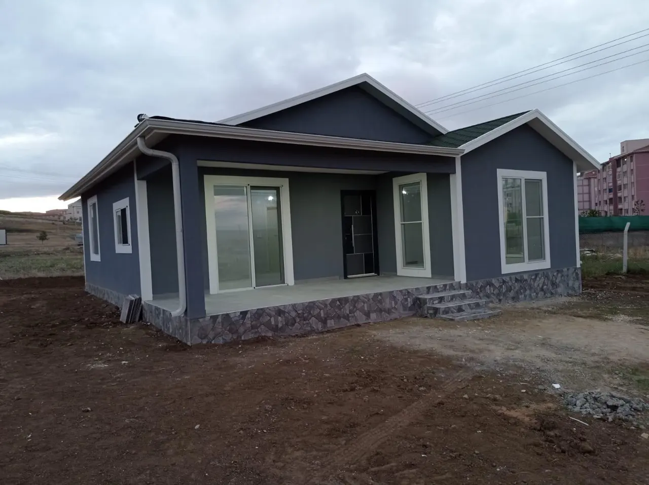 100 m² Çelik Ev: gri cephede giriş köşesi