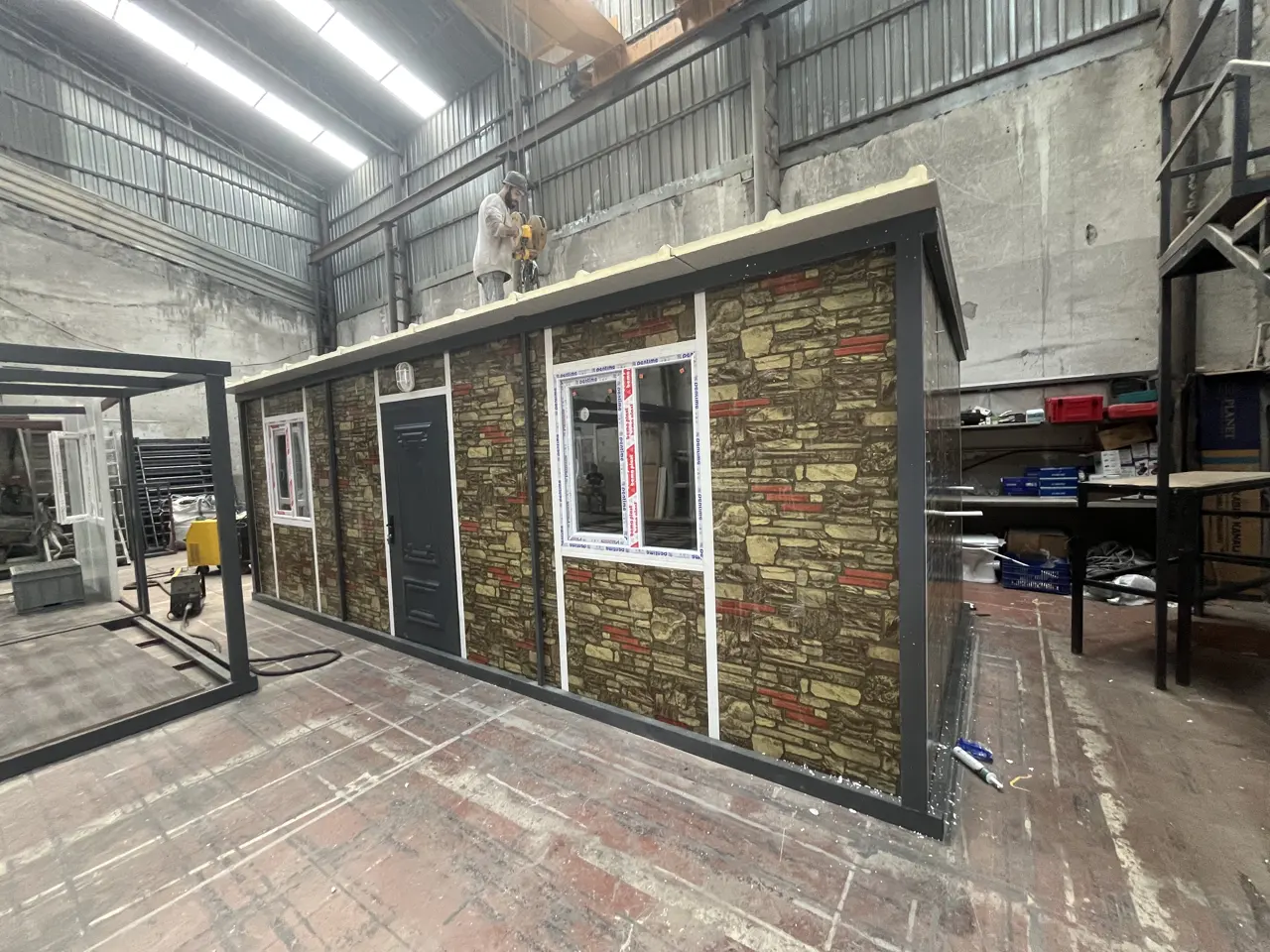 21 m² Modüler Ev: üretim alanında taş desenli cephe