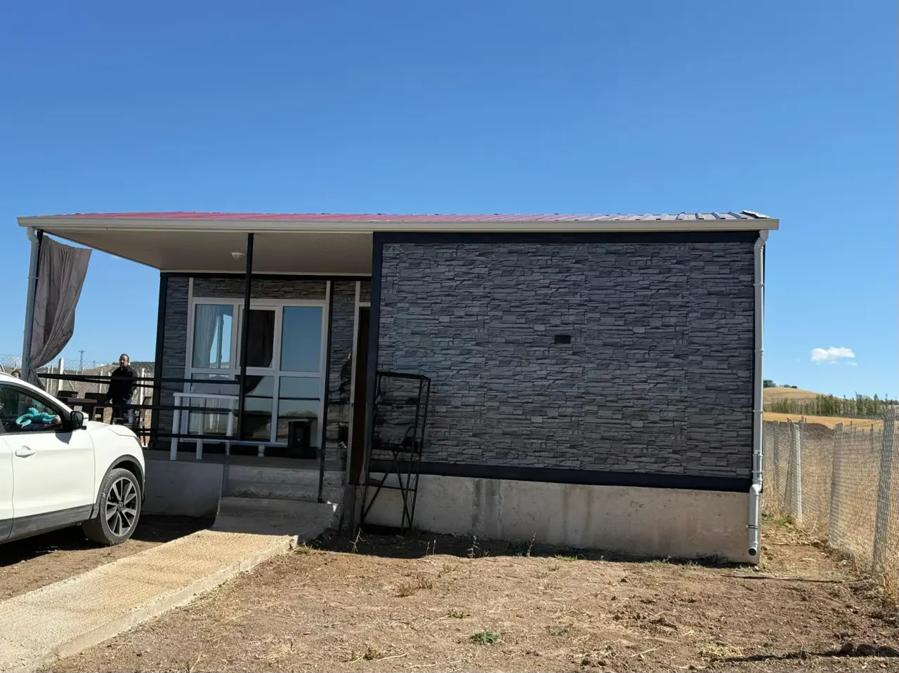 56 m² Modüler Ev: taş desenli yan duvar ve veranda